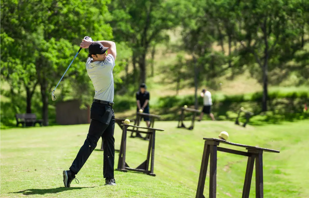 A golf player swings his club